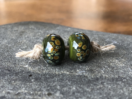 2x handmade glass beads - frit - jitterbug on cave green
