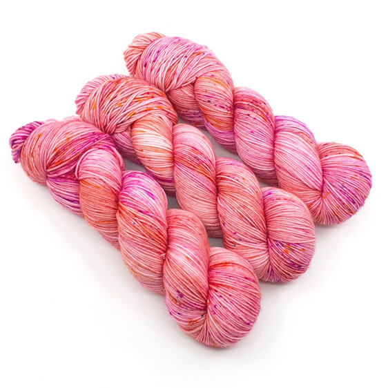 3 twisted skeins of yarn in apricot/peach with gold, hot pink and blue speckles