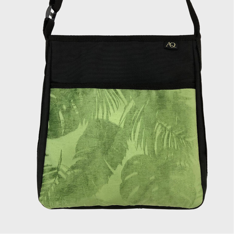 A gree fern and Monstera leaf fabric on the front pocket of the handbag