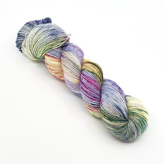 A pkein of variegated speckled yarn in lilac, blue, green, yellow and pink