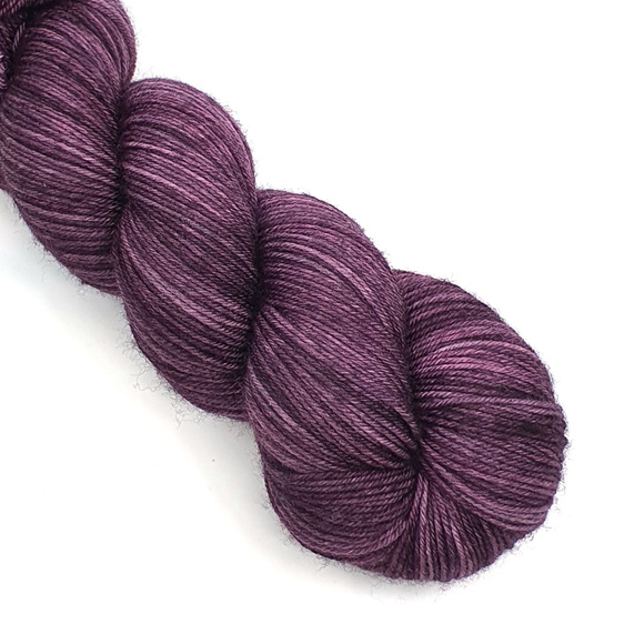 a skein of 85/15 merino/nylon yarn in an aubergine purple tonal colour