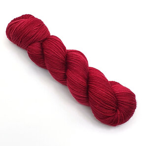 a skein of DK weight 100% merino wool in a semi-solid red