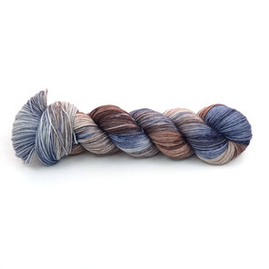 A skein of variegated yarn in subtle brown, blue and grey.