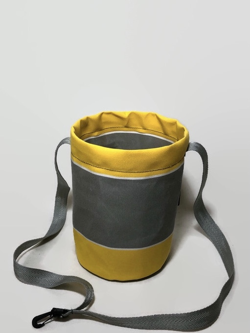 A yellow and grey  peg bag made to handle all weather conditions.
