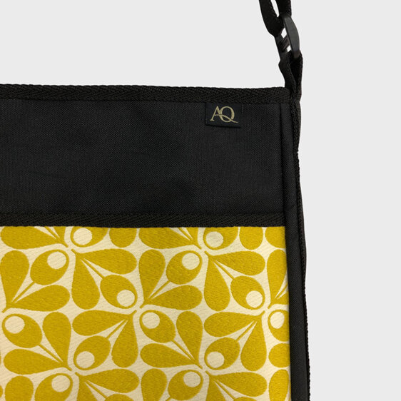 An acorn design in yellow  by Orla Kiely is on the front pocket of this handbag