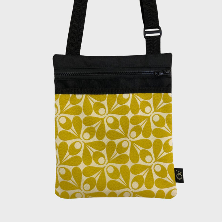 An Orla Kiely yellow acorn fabric adorns the front pocket of this small bag.