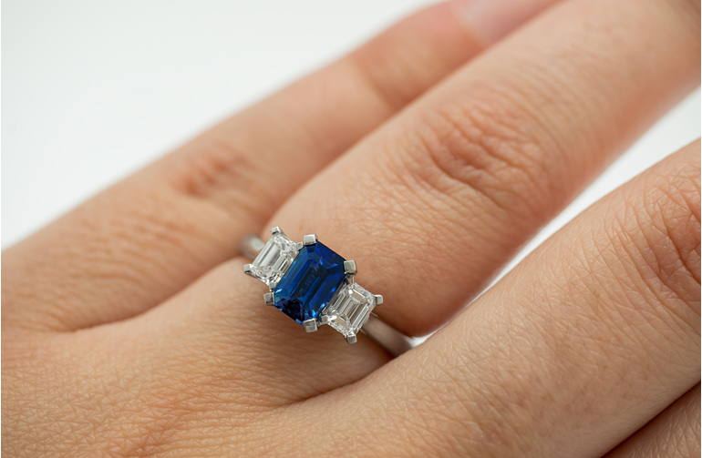 Blue emerald cut sapphire and diamond three stone ring platinum white gold