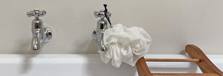 body pouf cotton body washer hanging on tap