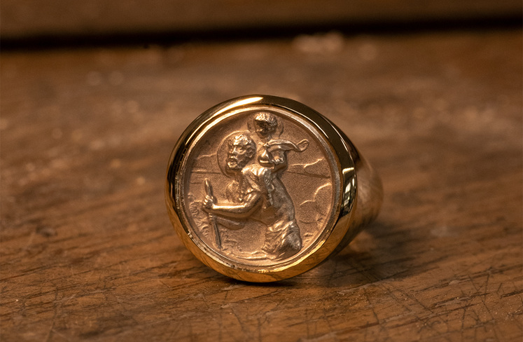 Cade's custom bespoke wedding ring using his heirloom St. Christopher medal