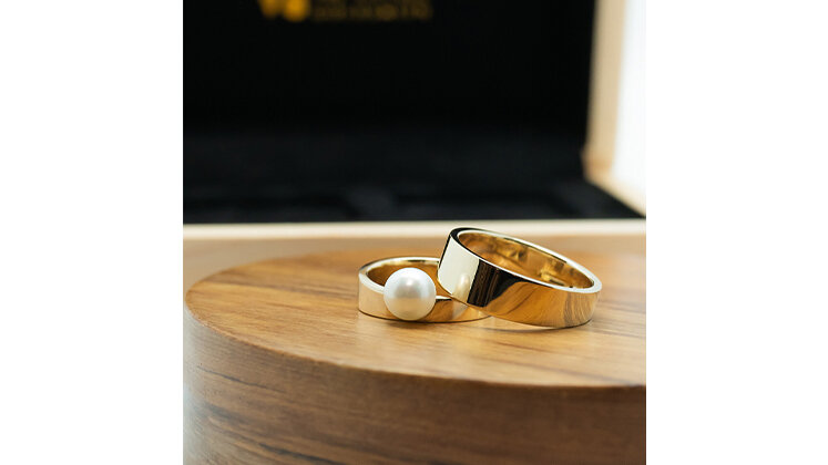 Custom bespoke yellow gold asymmetrical wedding rings pearl set