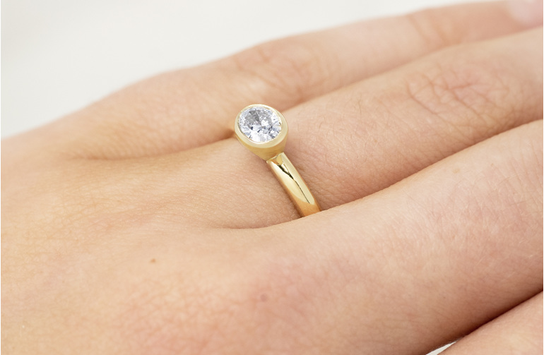 East-west bezel set oval cut diamond solitaire ring engagement dress yellow gold