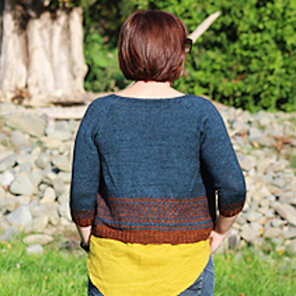 image is of female with back turned to camera wearing a blue and rust cardigan