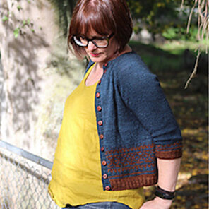 image shows a female wearing a yellow top with a blue and rust knit cardigan