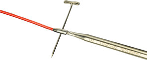 image shows a red cable connected to a stainless steel needle with a key