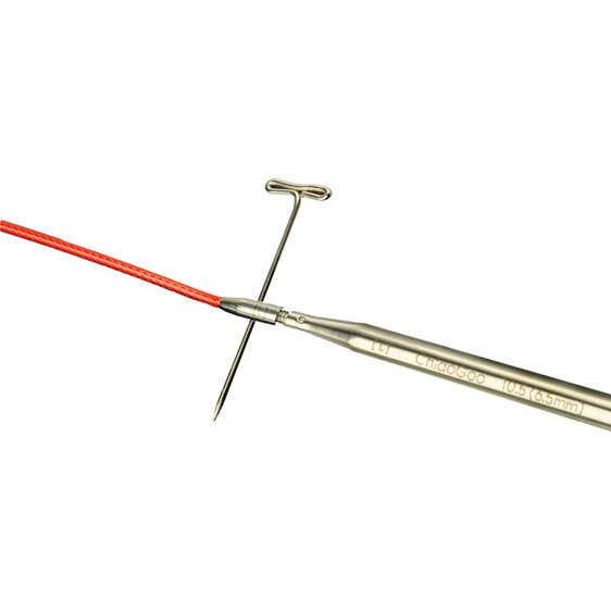 image shows a red cable connected to a stainless steel needle with a key