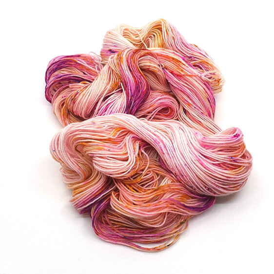Image shows a twisted skein of yarn in cream, pink and gold colours