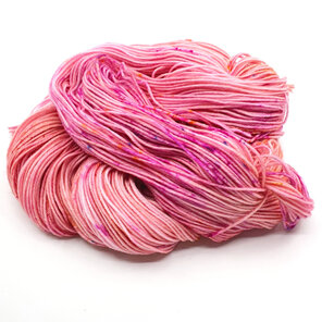 loose skein of yarn in apricot/peach with hot pink, gold and blue speckles