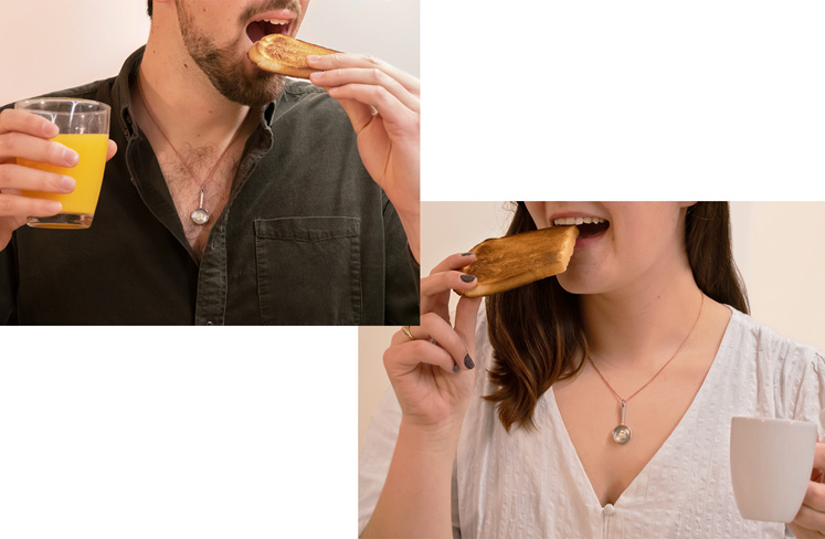 man and woman both wearing unique diamond frying pan pendant eating breakfast