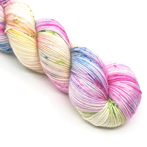 part skein of yarn in pink, blue, green, lilac and yellow hues laid diagonally