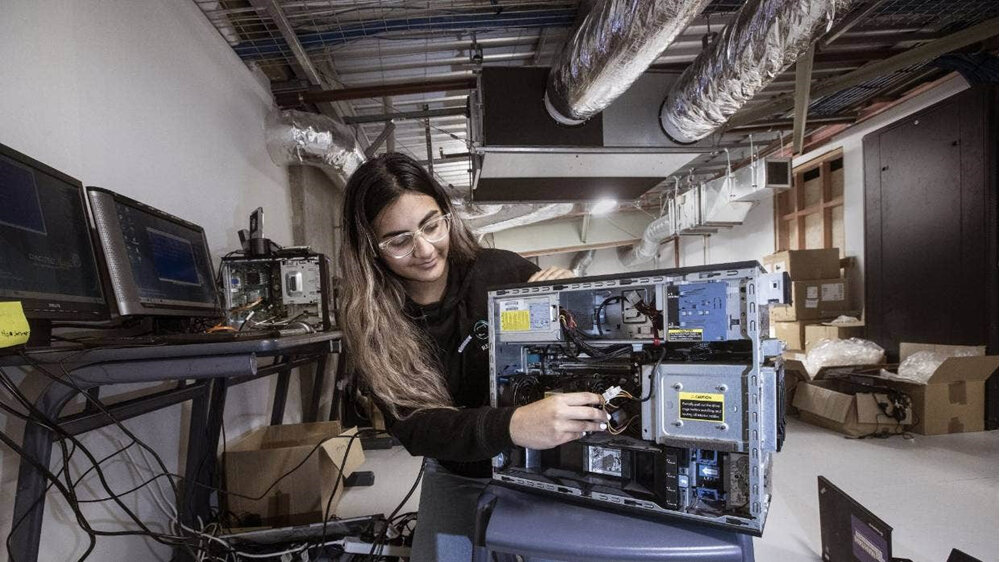 Photo by Kevin Stent from Stuff of female repairing a broken computer to donate