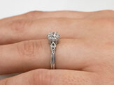 Platinum diamond solitaire engagement ring with crossover band accent detail
