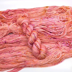 skein 100% DK merino peachy pink with speckles in yellow, hot pink with blue pop