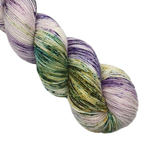 skein of 4ply merino/nylon yarn in variegatad cream, purple and green w speckles