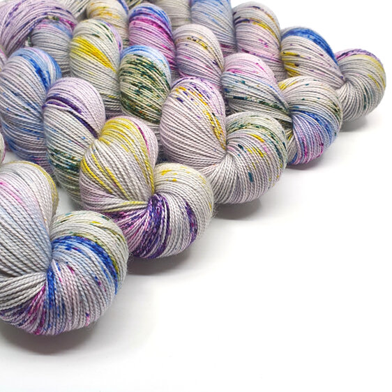 skein of 75/25 merino/nylon grey base with yellow blue green pink purple speckle