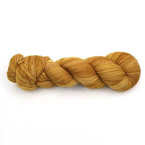 skein of 85/15 merino/nylon yarn in a semi-solid golden mustard colour