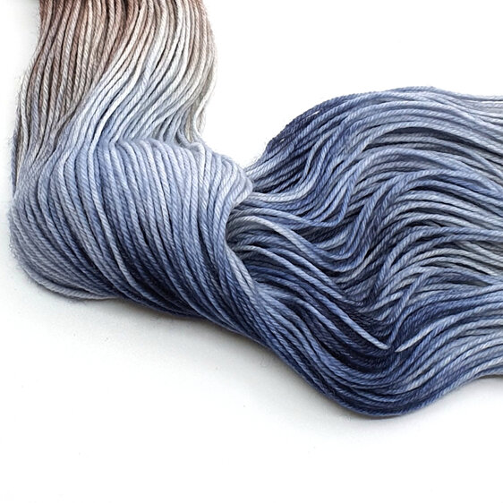 skein of merino/nylon yarn in a variegated light grey, steel blue and brown