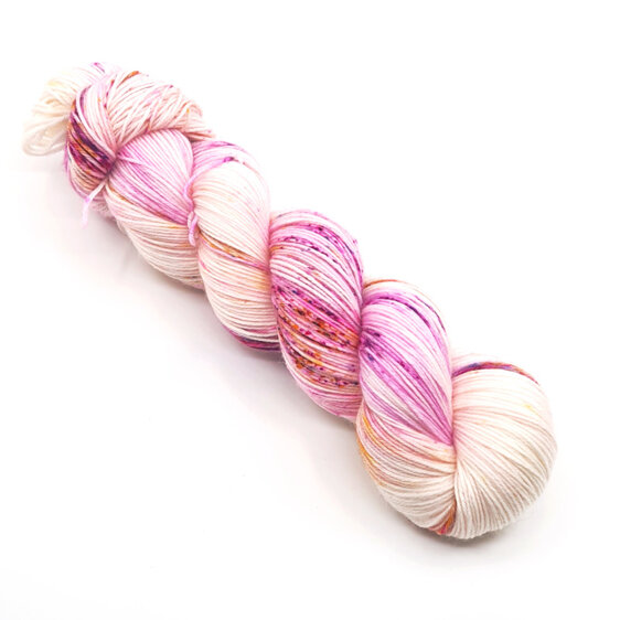 skein of yarn in natural cream base speckled in pink, gold & blue