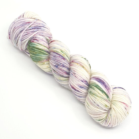 skein of yarn in natural cream speckled with purple and green with speckles