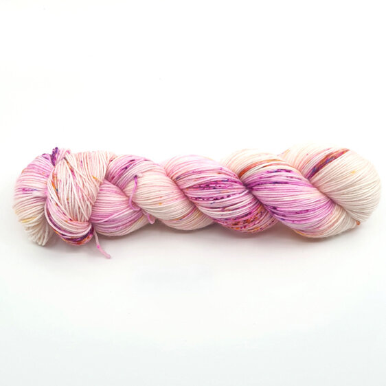 skein of  yarn on natural cream base speckled in pink, gold & blue