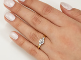 Three stone diamond engagement ring with koru motif in band 18ct yellow gold