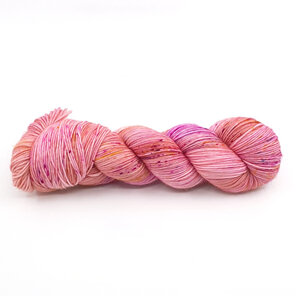 twisted skein of yarn in apricot/peach with hot pink, gold and blue speckles