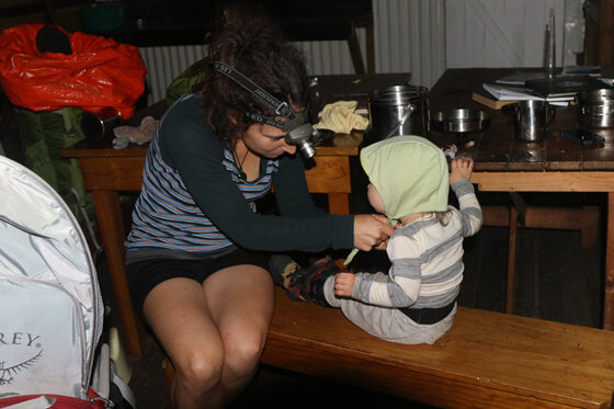 winter tramping doc hut interior with a toddler getting ready nz